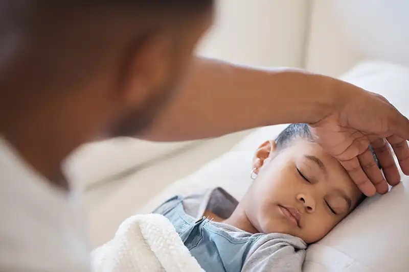 A dad checking his daughter's fever temperature