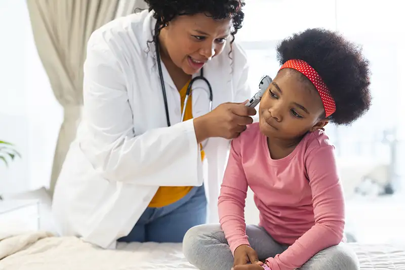 african-american-female-doctor-examining-girl