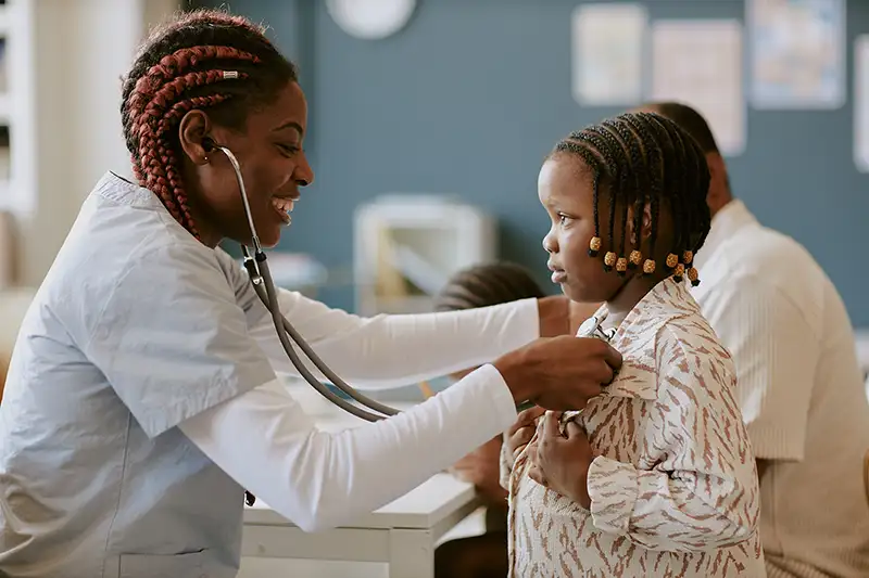 smiling-nurse-examining-child-in-medical-office